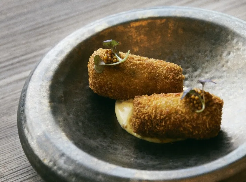 Dois croquetes fritos num prato branco